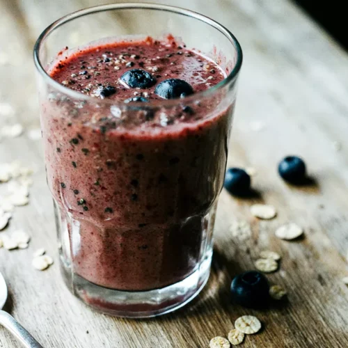Thick berry smoothie in a glass showing natural texture and seeds.